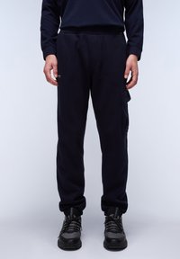 Navy sweatpants made of cotton blend, featuring an elastic waistband, side pockets, and a cargo pocket on the left leg. Text logo on front.