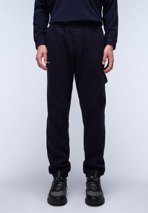 Pantalones de chándal de color navy fabricados con mezcla de algodón, con cintura elástica, bolsillos laterales y un bolsillo tipo cargo en la pierna izquierda. Logotipo en texto en la parte frontal.