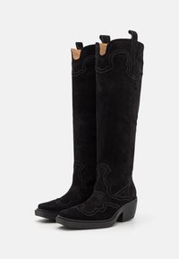 Black suede knee-high boots with a pointed toe, decorative stitching, and a block heel. Features a scalloped top edge and pull tabs.