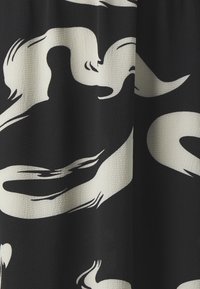 Tissu noir présentant un motif abstrait de tourbillons blancs, avec une finition texturée et des formes fluides et organiques tout au long.