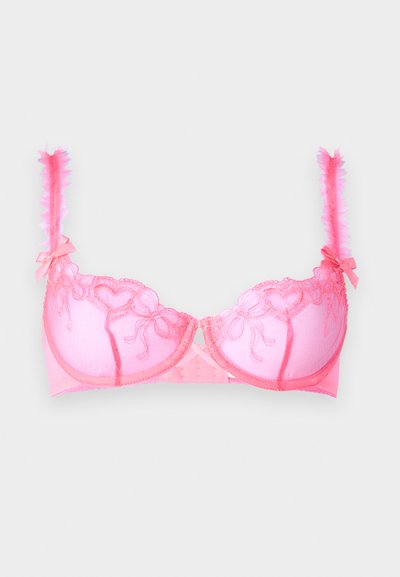 Sujetador de encaje rosa con patrones de corazones, copas acolchadas y tela transparente. Presenta tirantes con volantes y pequeños lazos como acentos decorativos.