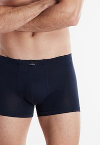 Marineblauwe boxershorts van rekbare stof, met een gemarkeerde tailleband en een aansluitend ontwerp, geschikt voor dagelijks gebruik.
