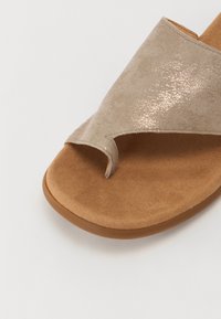 Sandali in suede beige con una finitura scintillante, design open-toe e una soletta marrone morbida con forme contornate per il massimo comfort.