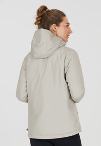 Hellbeige Pufferjacke mit Kapuze, die eine glatte, glänzende Oberfläche, elastische Bündchen und einen leicht verlängerten Rücken für zusätzlichen Schutz bietet.