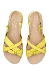 Żółte skórzane sandały z krzyżowym wzorem pasków, z wygodną wkładką i bocznym zapięciem do regulacji. Gładka tekstura.
