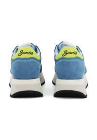 Sneaker blu in suede con suola bianca e nera. Presenta una linguetta sul tallone di colore verde neon con "Sun68" in scrittura nera. Dettagli cuciti sulla parte superiore.