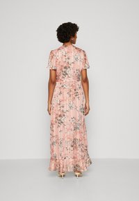 Maxi dress in pink fabric with floral patterns, short sleeves, and a fitted bodice. Features a ruffled hem and smooth texture.