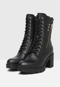 Black leather ankle boots with a chunky heel. Features laced front, gold-tone eyelets, and a side zipper. Textured sole for traction.