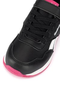 Czarny but sportowy z teksturowaną skórzaną cholewką, czarnymi sznurówkami, białymi akcentami po bokach i różowym detalem na podeszwie.