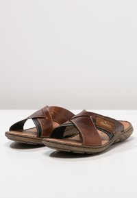 Sandales à glissière en cuir marron avec un design à lanières croisées, semelle intérieure texturée et accents noirs ; semelle synthétique durable pour plus de confort.