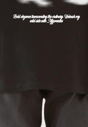 Schwarze Kleidung mit weißer, kursiver Aufschrift auf der Brust: "Kühne Eleganz, die das Gewöhnliche übertrifft. Entfessele meine wilde Seite mit Tiffanielles".