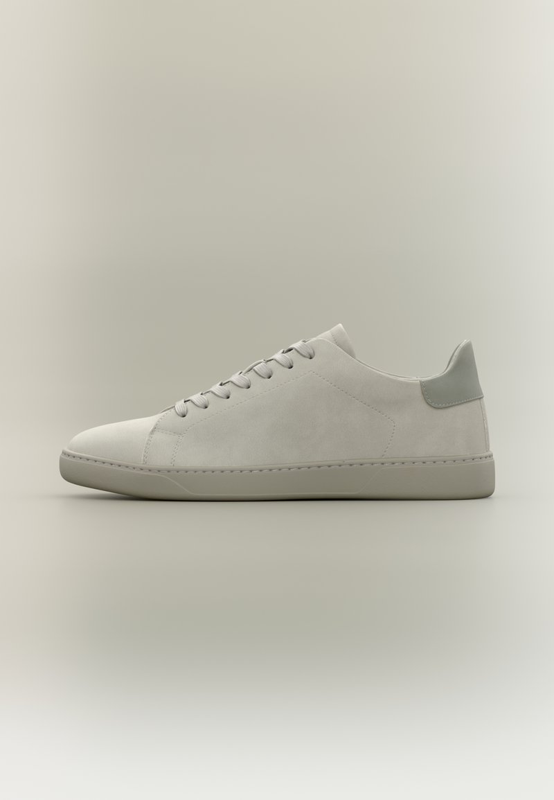 Baskets à lacets gris clair, basses, avec texture en daim et semelle en caoutchouc, vues de côté sur un fond neutre.