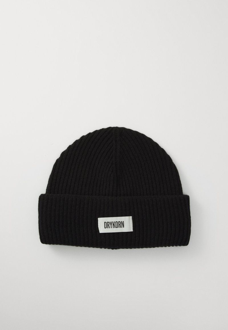 Beanie negru, din tricot cu nervuri, cu margine pliată și o etichetă albă pe care scrie "DRYKORN." Prezintă o textură fină și un vârf rotunjit.