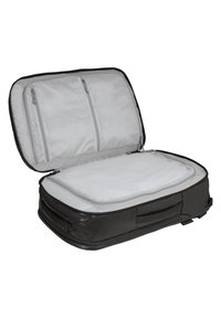 Bolsa de viaje de tela suave negra con un interior gris, que cuenta con dos compartimentos de malla con cremallera y una sección principal amplia para empacar.