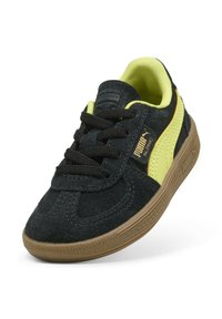 Sneaker in suede nero con accenti giallo neon, suola in gomma testurizzata e lacci neri. Presenta un logo sul lato e un colletto morbido e imbottito.