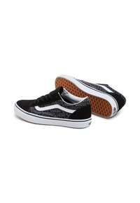 Sneakers Vans in bianco e nero con una tomaia nera testurizzata caratterizzata da un motivo logo, accenti bianchi e una suola in gomma colorata.