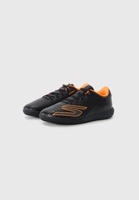 Svarta sportskor med texturerad ovandel, orange detaljer och snörning. Har en rundad tå och en dämpad sula för komfort.