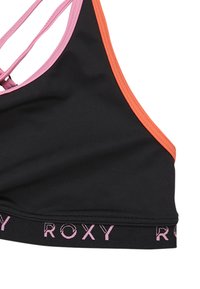 Soutien-gorge de sport noir avec des bretelles roses et orange, comportant une bande rose de marque en bas. Le design inclut un dos croisé.