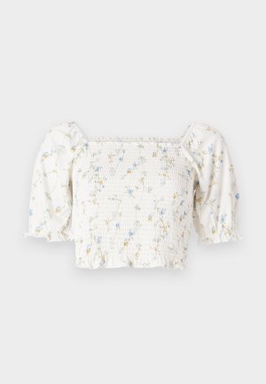 White floral blouse with short puff sleeves, smocked bodice, and delicate blue and yellow flower patterns throughout.