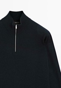 Donkerblauwe trui met hoge kraag en een kwart ritssluiting. Gemaakt van een zachte brei stof met een gladde textuur. Eenvoudig design zonder patronen.