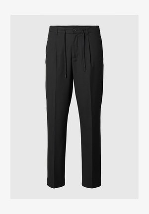 Musthave mustriibul püksid mustas värvitoonis, millel on reguleeritav vöökoht, esipliiatsid ja sirge jalgade lõige. Sile tekstuur.