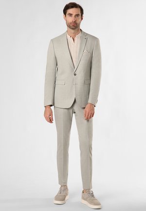 Hellgrauer Anzug mit einreihigem Sakko, Hose mit flacher Front und beigen Sneakers. Glatte Textur, dezentes Muster und dekoratives Einstecktuch.