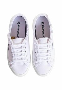 Sneakers bianchi in tela con texture a coste, punta rotonda, design con lacci e orlo sfilacciato. Presentano il logo Superga sul lato e sulla soletta.