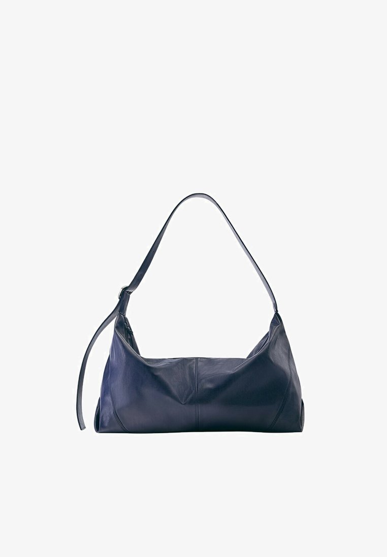Sac à bandoulière en cuir noir avec une sangle unique et des détails de couture minimalistes sur fond blanc.