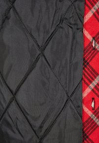 Quilted black fabric with diamond pattern on the left, paired with red plaid fabric featuring white and black accents on the right.