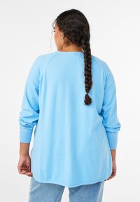 Helehall sinine üle suuruses kampsun pikkade varrukatega, soonikkoes mansettidega ja ümarate äärega, esitatud tagantpoolt, sileda tekstuuriga.