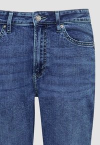 Donkerblauwe denim jeans met een klassieke vijf-pocket ontwerp, metalen knoopsluiting en contrasterende stiksels langs de naden.