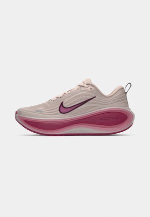 Adidașii Nike ZoomX de alergare în bej deschis, cu un superior texturat, o talpă intermediară curbată de culoare roz și accente de culoare purpurie pe logo și talpa exterioară.