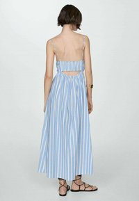 Blue and white striped maxi dress with open back, adjustable straps, and gathered waist. Lightweight fabric with a flowy silhouette.
