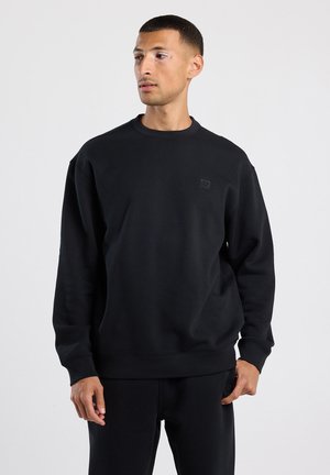 Zwarte sweatshirt met een ronde hals, geribbelde manchetten en tailleband. Voorzien van een klein zwart logo op de borst. Gemaakt van een gladde stof.