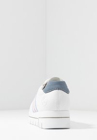 Sneaker bianco con tomaia in pelle testurizzata, tallone in suede blu chiaro e tre strisce orizzontali in rosa e blu. Suola bianca spessa.