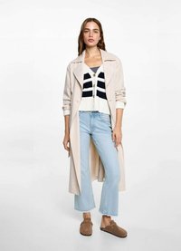 Trench beige sobre un cárdigan a rayas blancas y marinas, jeans cortos de mezclilla azul claro y zapatos marrones de slip-on. Diseño sencillo y texturas suaves.