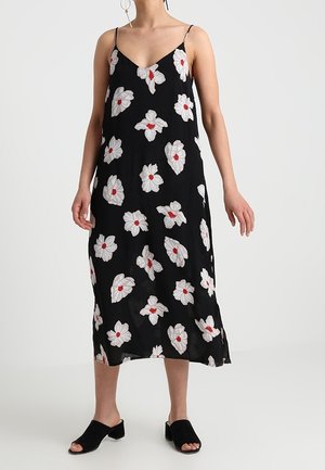 Černé bezramínkové šaty s bílými květinovými vzory a červenými středy, vyrobené z lehké látky, s volným střihem a délkou ke kotníkům.