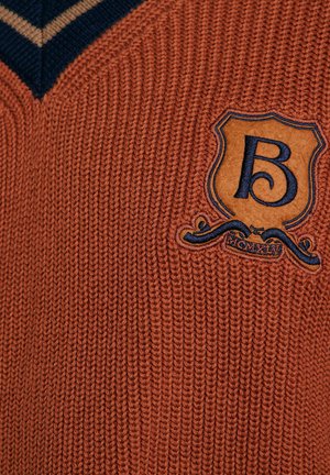 Sweter w kolorze rdzawym o głębokim dekolcie w kształcie litery V, z kontrastującymi granatowymi paskami oraz teksturowaną naszywką z wytłoczonym litera "B".