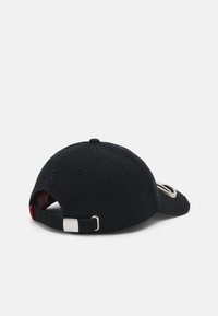 Svart baseballcaps med flat skjerm, teksturert stoff og en sølvmetallklips på den justerbare stroppen. Har en logo brodert på forsiden.