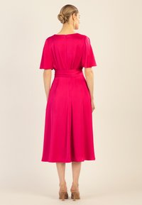 Fuchsiafarbenes Satin-Kleid mit kurzen, schwingenden Ärmeln, tailliertem Schnitt und knielangem Rock, der einen Rückenschlitz und einen diskreten Reißverschluss hat.