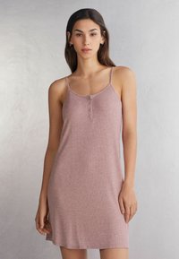 Sukienka bez rękawów w miękkim różowym kolorze, o luźnym kroju, z zapięciem na guziki z przodu i cienkimi, regulowanymi ramiączkami. Gładka tekstura.
