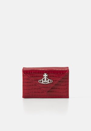 Red faux-crocodile leather wallet with a silver logo accent, triangular flap design, and neat stitching along the edges. Compact rectangular shape.