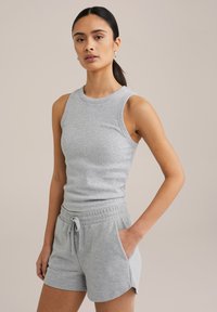 Hallikas puuvillane tank top ümmarguse kaelusega ja varrukateta disainiga, koos sobivate hallide lühikeste pükstega, millel on elastne vöökoht ja küljetaskud.