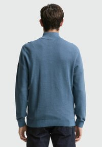 Blauer strukturierter Pullover mit Polokragen, langen Ärmeln und gerippten Bündchen. Hat einen taillierten Saum und ein dezentes Logo-Detail am Ärmel.
