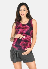 Canottiera premaman con base nera e stampa di foglie rosa, abbinata a pantaloni corti grigi con un dettaglio di legatura in vita. Tessuto liscio.