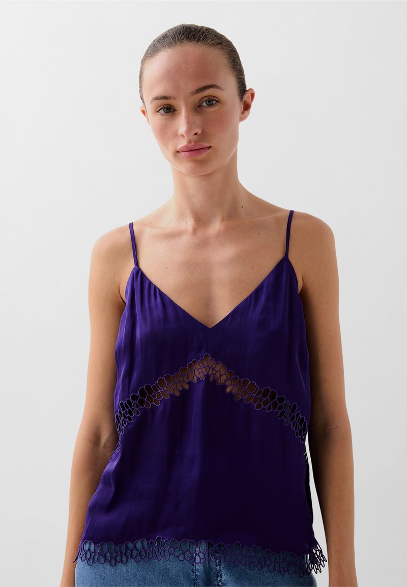 Camisón de seda morado con tirantes finos, que presenta un escote en V y detalles de encaje floral en el dobladillo y la sección media.