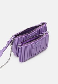 Fioletowa torebka z plisami, wykonana z teksturowanego materiału, z dwoma zamykanymi na zamek kieszeniami, srebrnym okuciem i odczepianym łańcuszkiem.