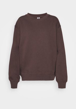 Bruine ronde hals trui met lange mouwen, geribde manchetten en zoom, getoond tegen een effen lichte achtergrond.