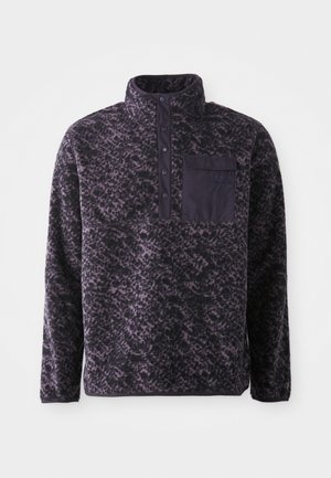 Fleecepullover in paars met een luipaardprint, kraag en knoopsluiting aan de voorkant. Beschikt over een borstzak met een donkere stofaccent.