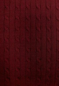 Bordowy dzianinowy materiał z teksturowanym wzorem warkocza przypominającym sznurek. Powierzchnia ma gładką fakturę z równomiernie rozmieszczonymi wypukłymi wzorami.